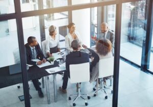 dynamics 365 business central consultants gathered around a boardroom discussing the 2025 release wave 2 of business central
